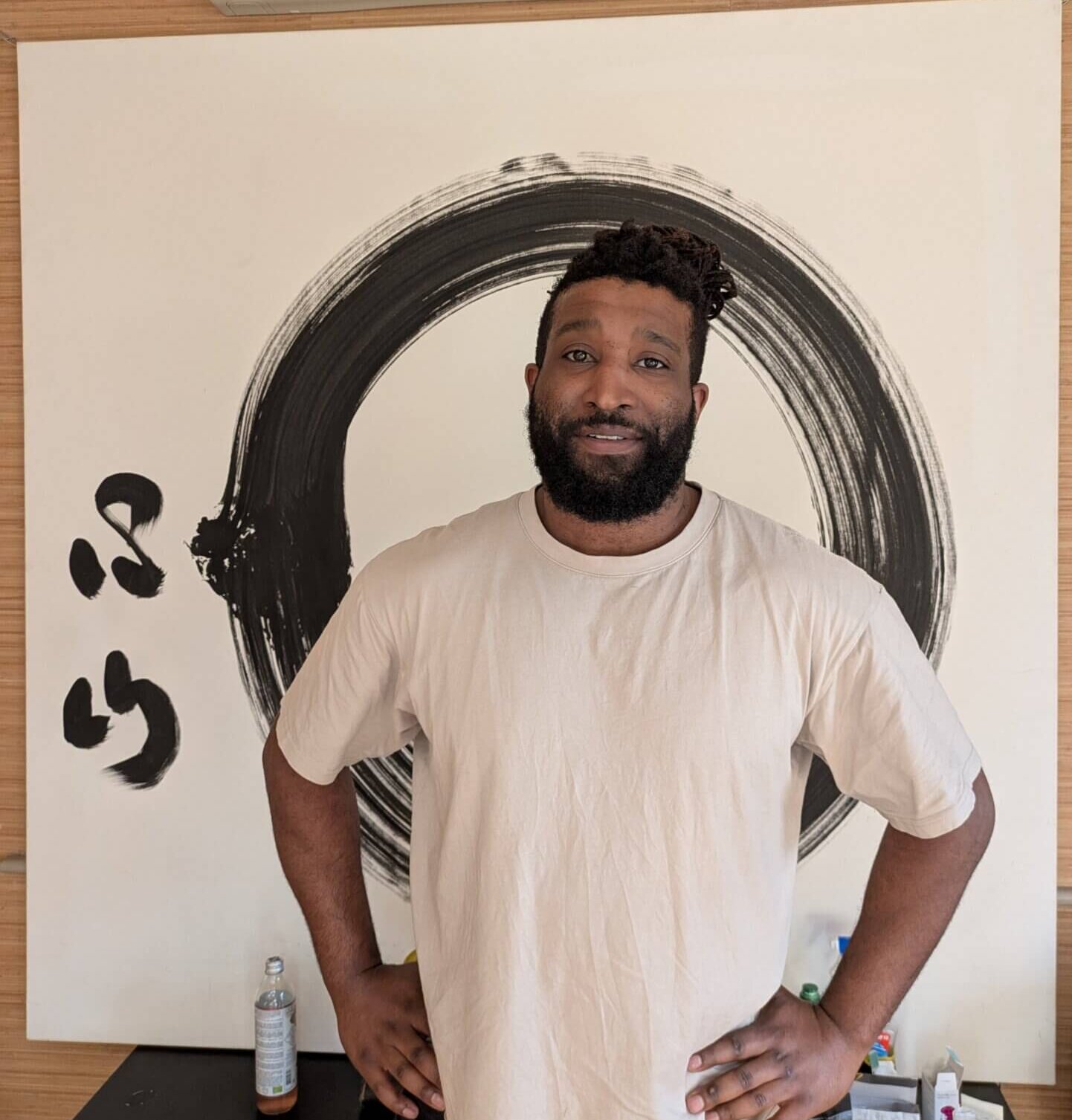 Jason Crowl acupuncturist at The Get Well Clinics behind a white and black zen painting