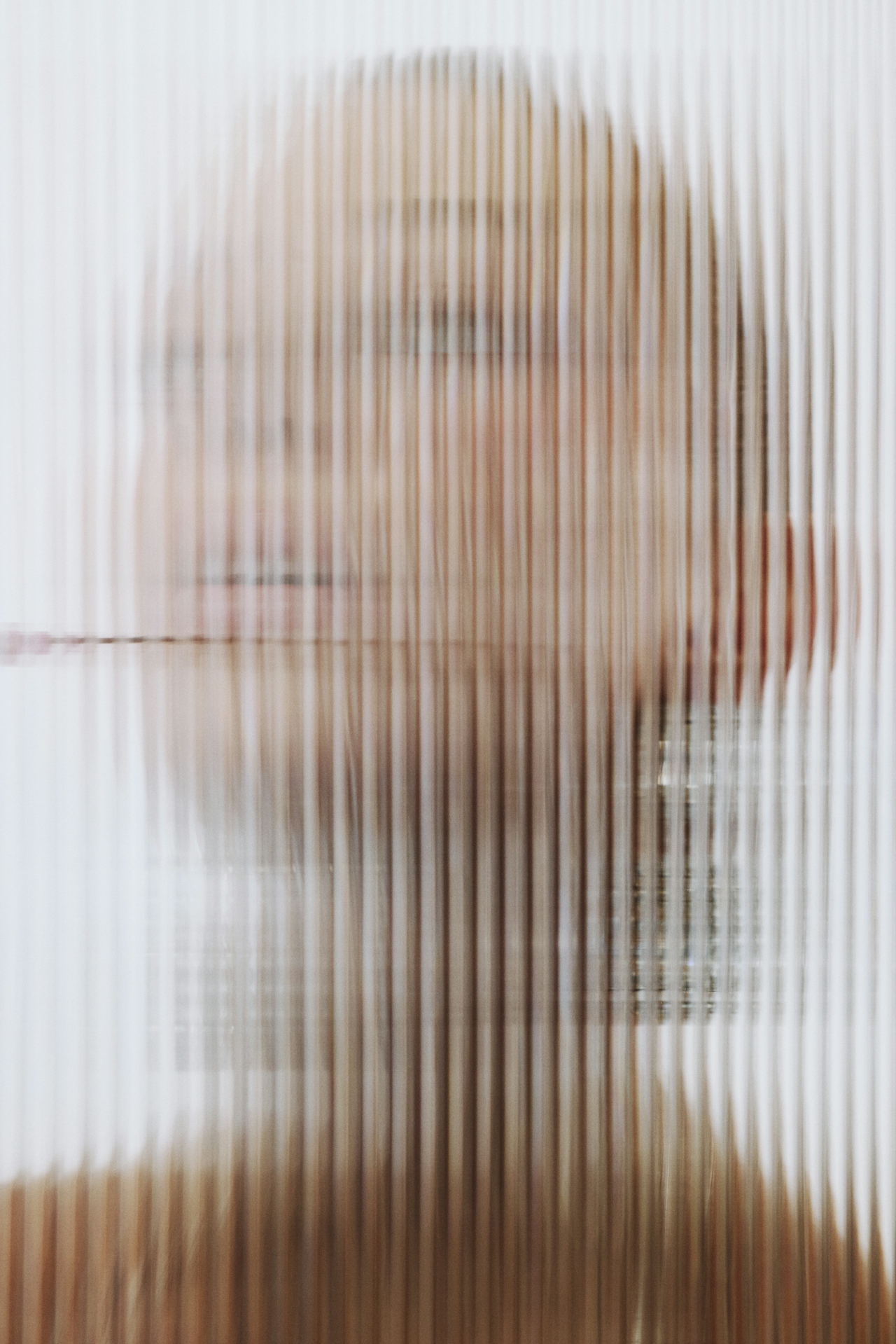A womans' face behind a horizontal screen that blurs the image.